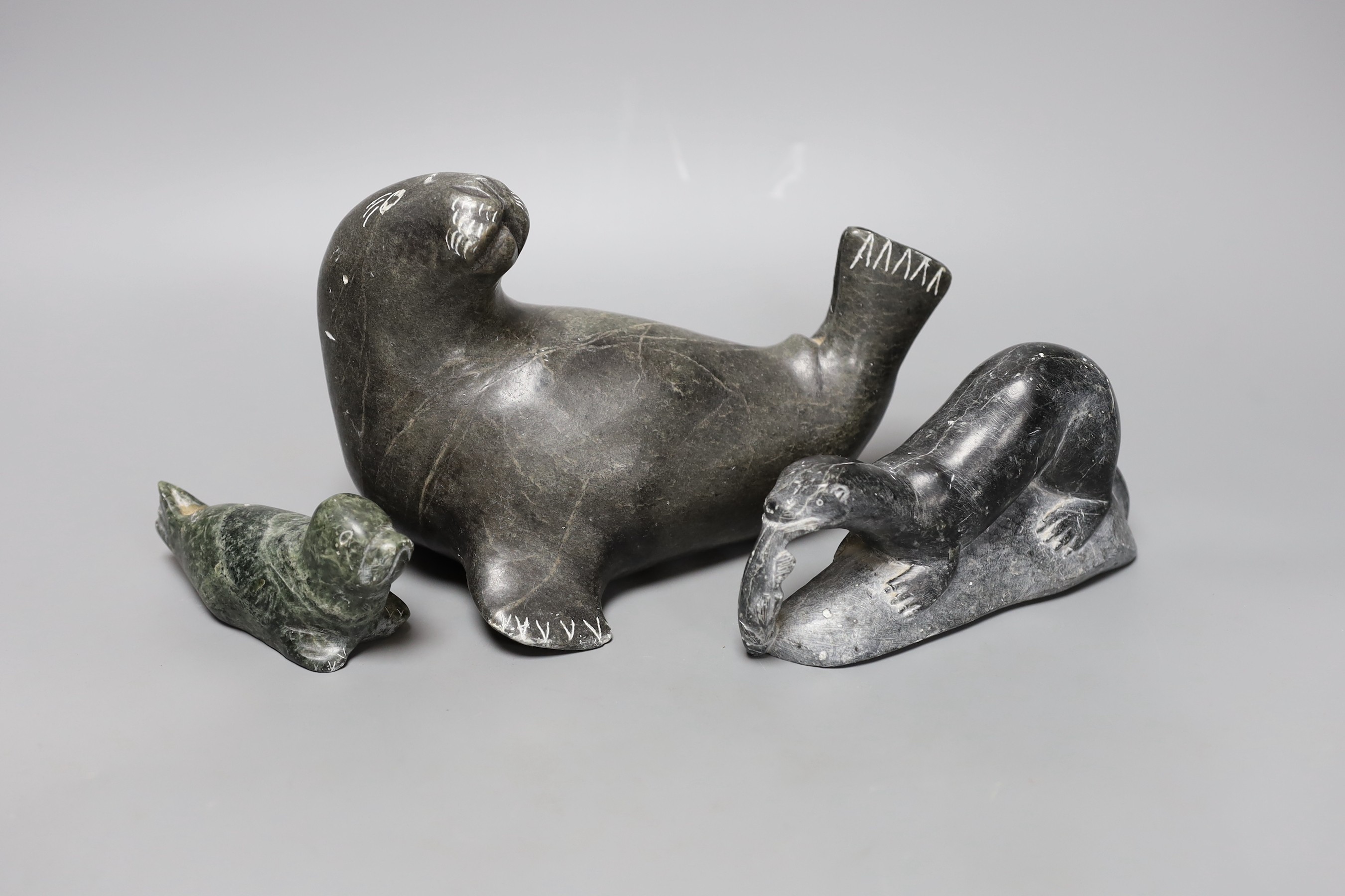 Three Inuit stone carvings, two seals and an otter. Largest 20cm long